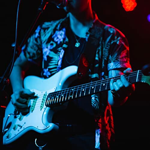 Musician playing electric guitar on stage.