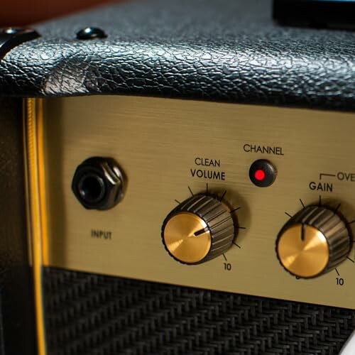 Close-up of guitar amplifier volume and gain knobs