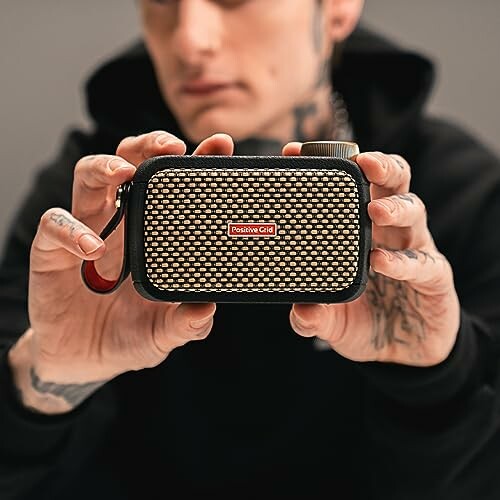 Person holding a compact portable speaker